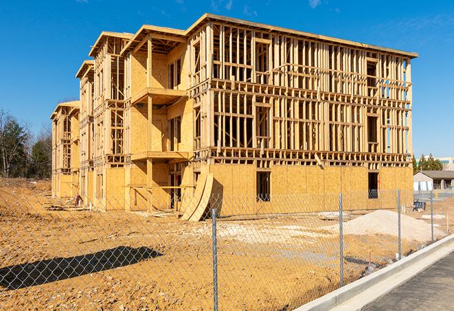 a temporary chain link fence winding around a construction site, outlining the project's progress in Pennsauken